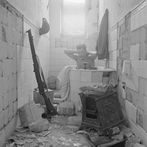 An Eight Army solider takes a bath amongst the ruins of Tobruk